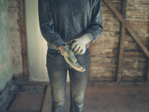 Worker putting on gloves in loft