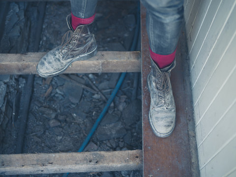 Feet of worker standing on floor joists