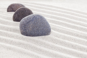 Three stones in sand, spa or zen concept
