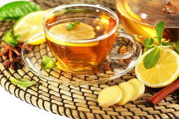 Cup of tea with ginger on a wicker mat, closeup