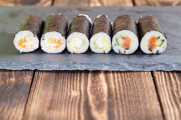 Homemade maki sushi rolls on a slate board