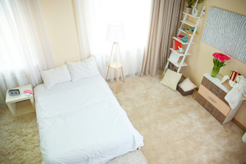 Bedroom interior in light tones with furniture and window