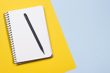 Office desk table with supplies top view. Notepad, pen and colorful paper. Copy space for text