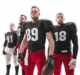 The four american football players posing with ball on white background