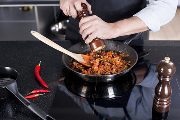 Chef preparing dishes in a frying pan