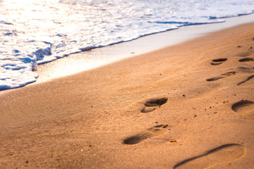Beach with footprints in sand at sunset, Beach travel, holiday at beach