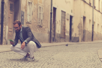 Handsome man using smartphone outdoors.
