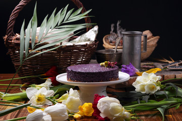 Cake on a plate, standing on the table among the spring flowers..