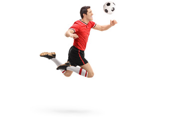 Football player heading a ball shot in mid-air