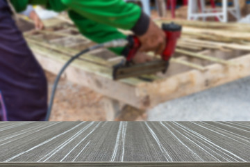 the worker use the drill to assemble the wooden seat