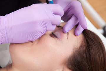 A woman getting permanent make up