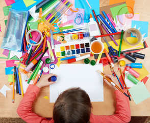 Child drawing top view. Artwork workplace with creative accessories. Flat lay art tools for painting.