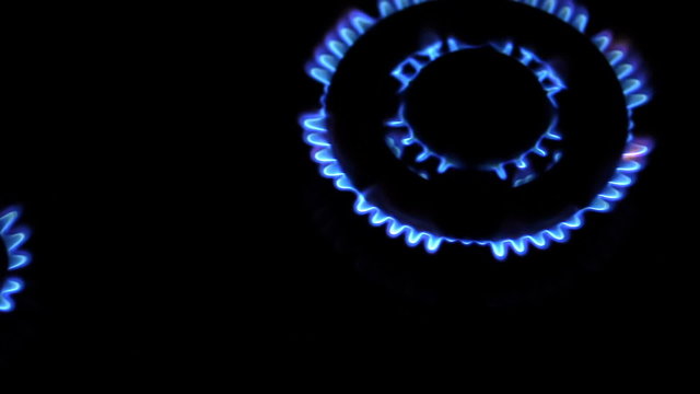 Moving around over kitchen gas stove with burners turned on