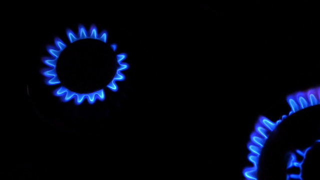 Two gas burners inflammation from kitchen stove, dark shot