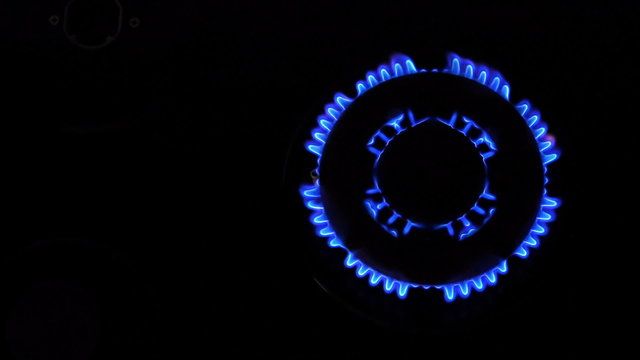 Natural gas inflammation from kitchen stove, dark shot, view from top