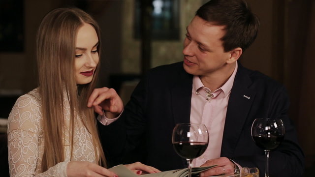 young happy couple in restaurant reading menu