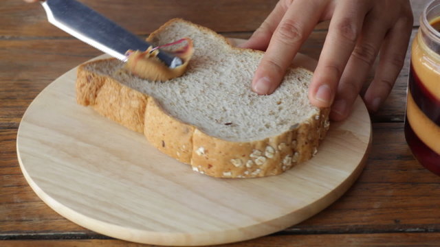 Topping whole wheat bread with peanut butter, stock video