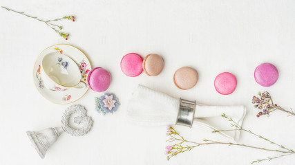 Macaroons with flowers and decorations on the white cloth