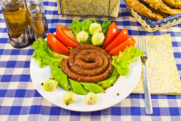 Sausages fried twisted into the spiral with vegetables