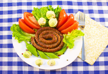 Sausages fried twisted into the spiral with vegetables