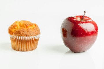 Healthy choices choosing to eat a muffin or a nice shiny red healthy apple