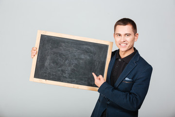 Smiling businessman holding blank board