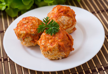 Meatballs in tomato sauce on a white plate