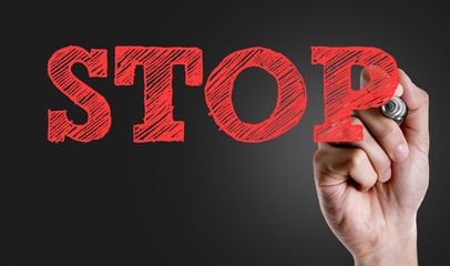 Hand writing the text: Stop