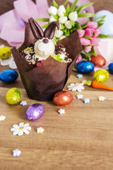 Fototapeta na wymiar Easter cupcake and chocolate eggs on wooden background