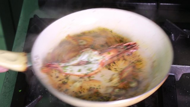 Stirring prawns in a frying pan