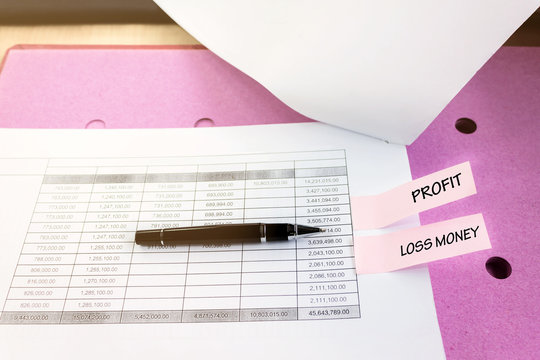 Financial document table with pen and text profit with loss mone