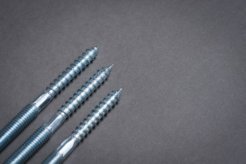 Metal screws on dark grey surface