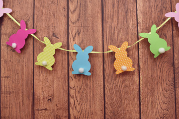 Easter bunnies hanging on a wooden background