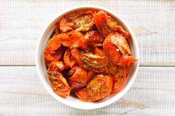 Italian cuisine, sun-dried tomatoes on white wooden background. top view.
