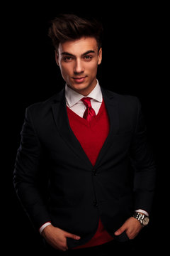 model in black suit and red tie, posing