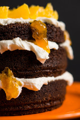 Chocolate cake with oranges on the wooden background