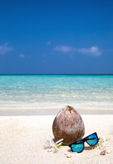 Kokosnuss mit Sonnenbrille am Strand