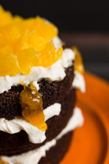Chocolate cake with oranges on the wooden background