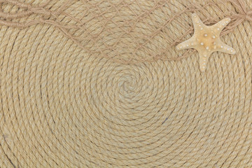 Fototapeta na wymiar starfish and sea network lie on background made of rope