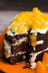 Chocolate cake with oranges on the wooden background