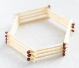 Matches stacked on top of each other in the shape of a hexagon
