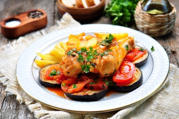 Braised chicken in white wine with eggplant, tomato and french fries.