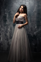Fototapeta na wymiar Fashion beauty portrait of gorgeous young woman with long curly hair in luxury evening dress