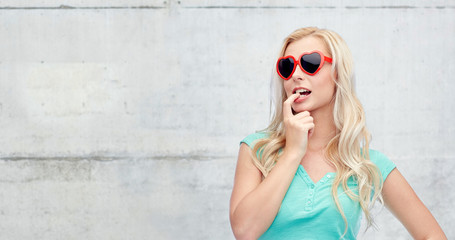 happy young blonde woman or teenager in sunglasses