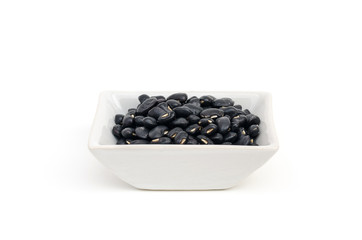 Black bean in a small square white bowl isolated on white background