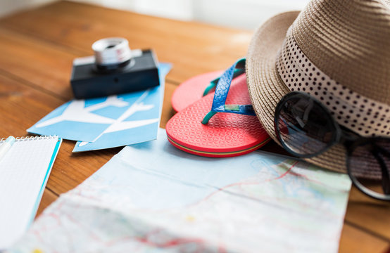 close up of travel map, flip-flops, hat and ticket