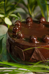 chocolate, glazed cake souffle, decorated with chocolate pieces on a glass stand
