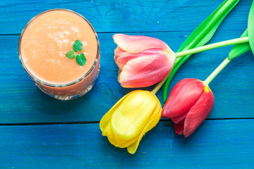 glass of fruit smoothies, and nearby are the tulips