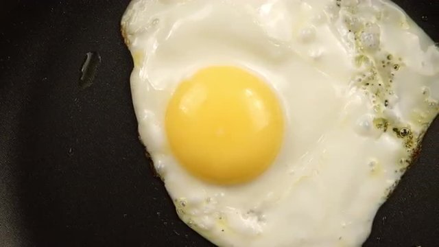TOP VIEW: Tracking of Close up of a fried eggs on the pan