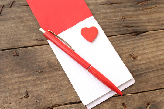 Love heart on notebook on wooden table 